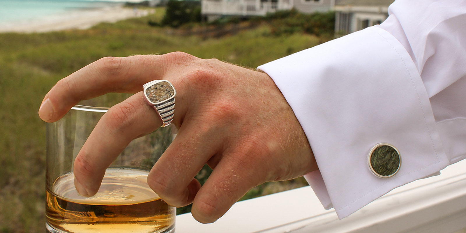 man holding a drink with cufflink gifts this season