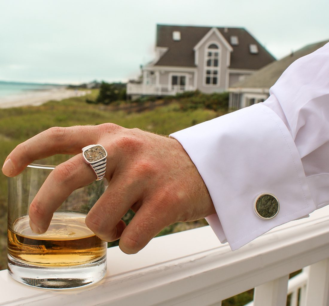 man holding a drink with cufflink gifts this season