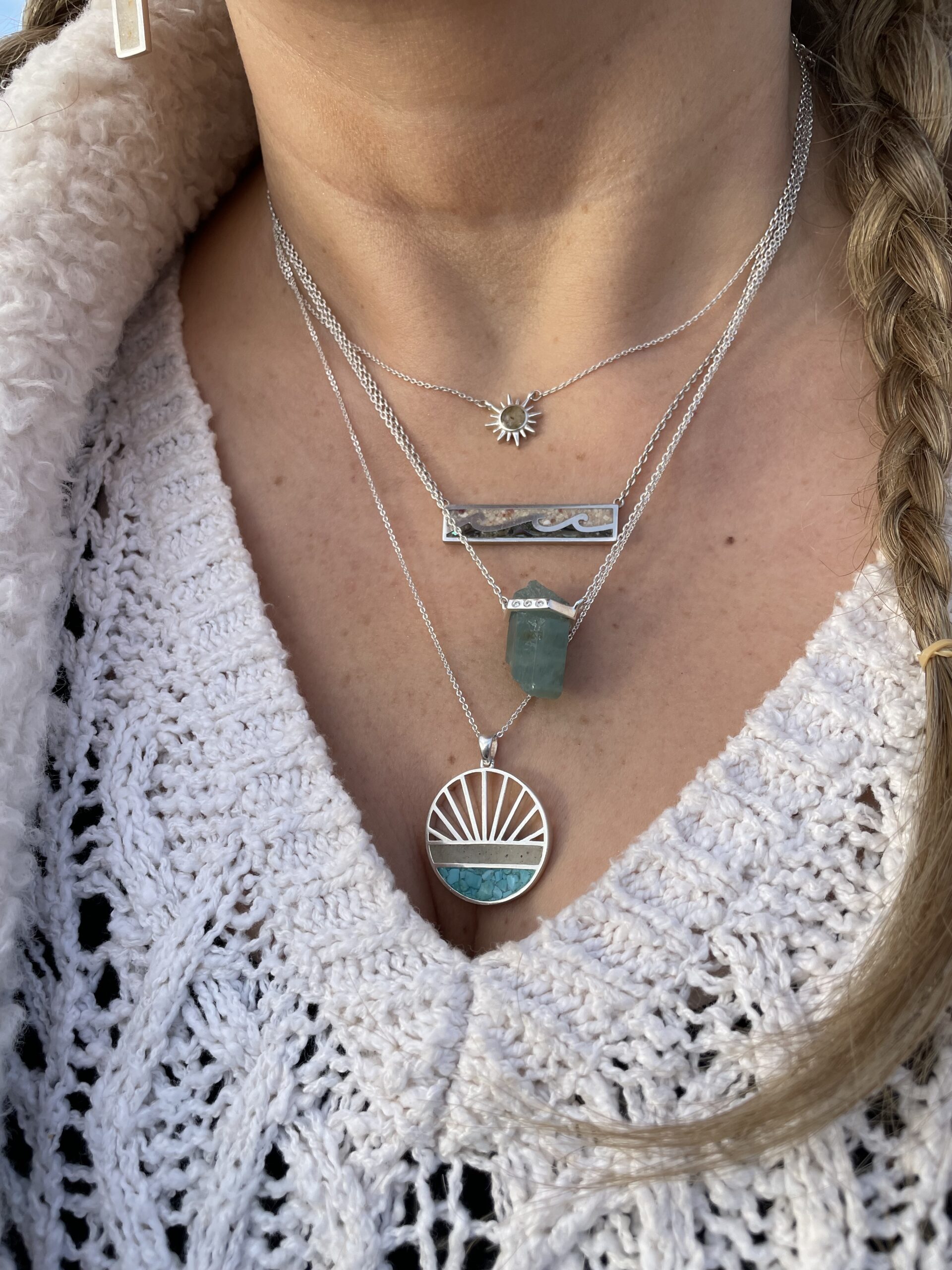 Sterling silver necklaces layered on neck, close-up.
