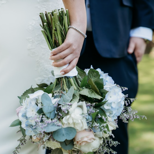 Close-up shot of the wedding bouquet upside down in bride's hand.