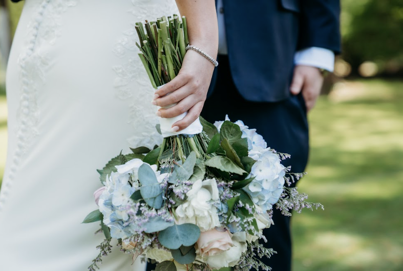 Close-up shot of the wedding bouquet upside down in bride's hand.
