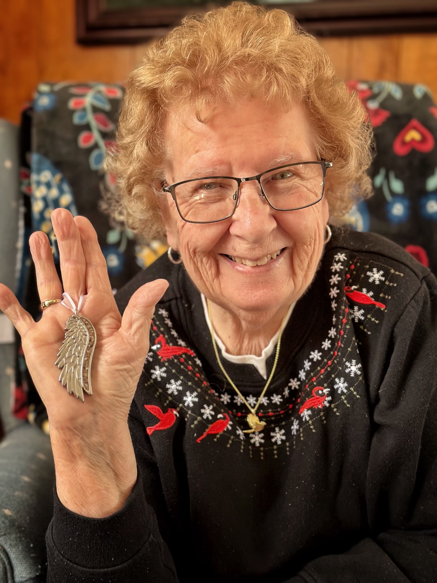 Jami's grandmother holding her angel wing ornament from Dune Jewelry