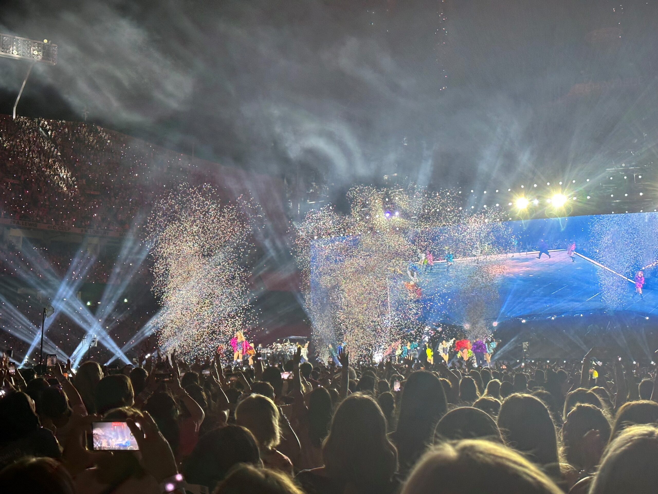 Confetti flying in the air, lights, and the concert stage at the Eras Tour.