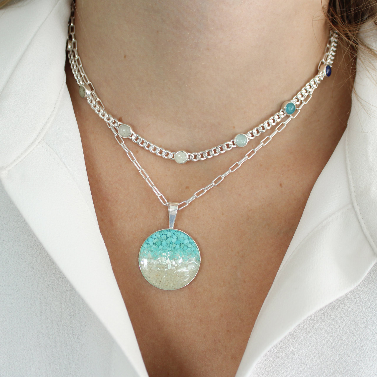 Sterling silver chain necklace with seven customizable sand and earth element settings, inspired by travel memories made in every continent.