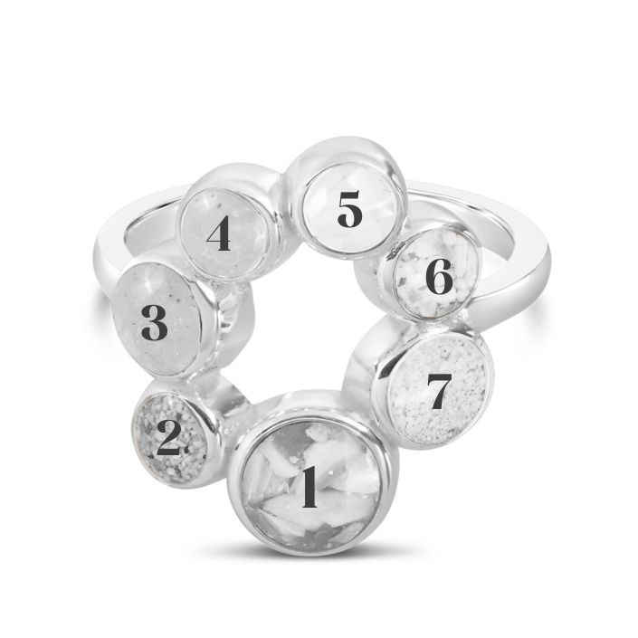 Sterling silver ring with seven customizable sand and earth element settings, inspired by travel memories made in every continent.